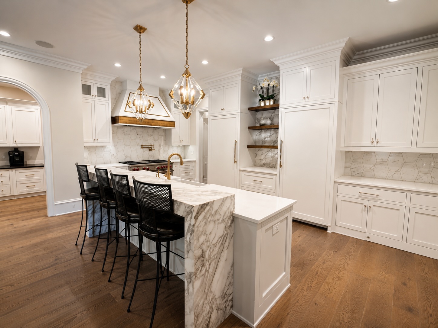 Chef's kitchen with Calacatta marble island, brass pendants, and professional-grade appliances