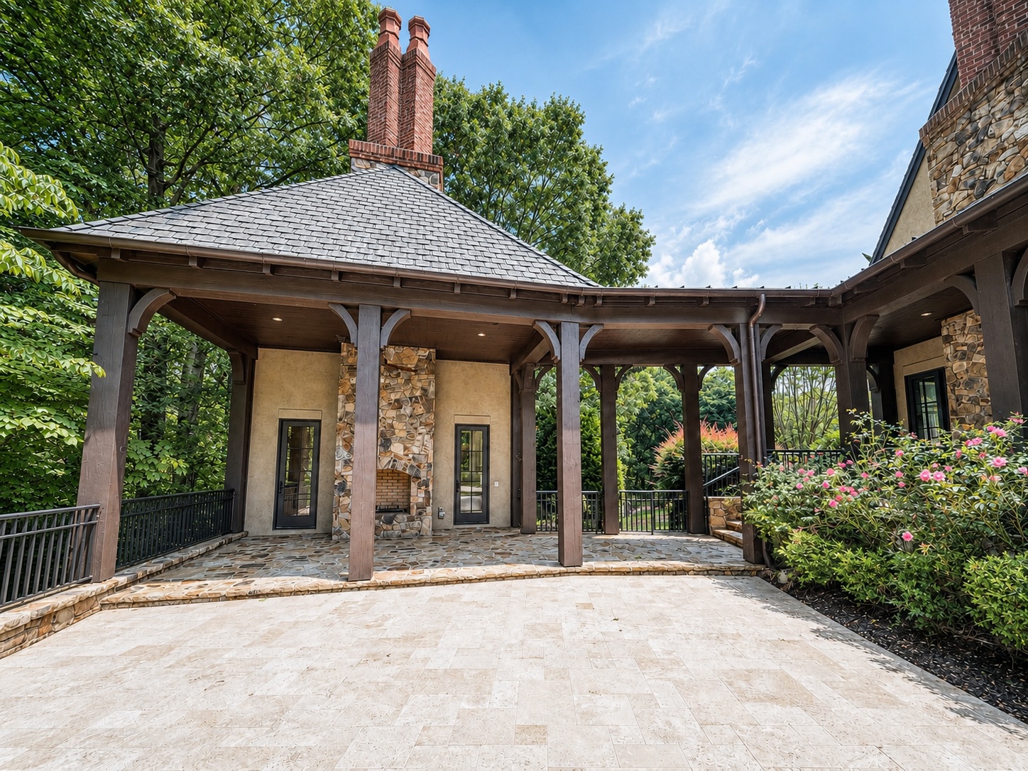 Covered outdoor pavilion with stone fireplace and flagstone terrace