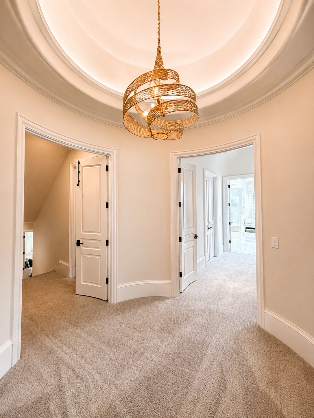 Primary suite rotunda entry with sculptural chandelier and inlaid marble floor