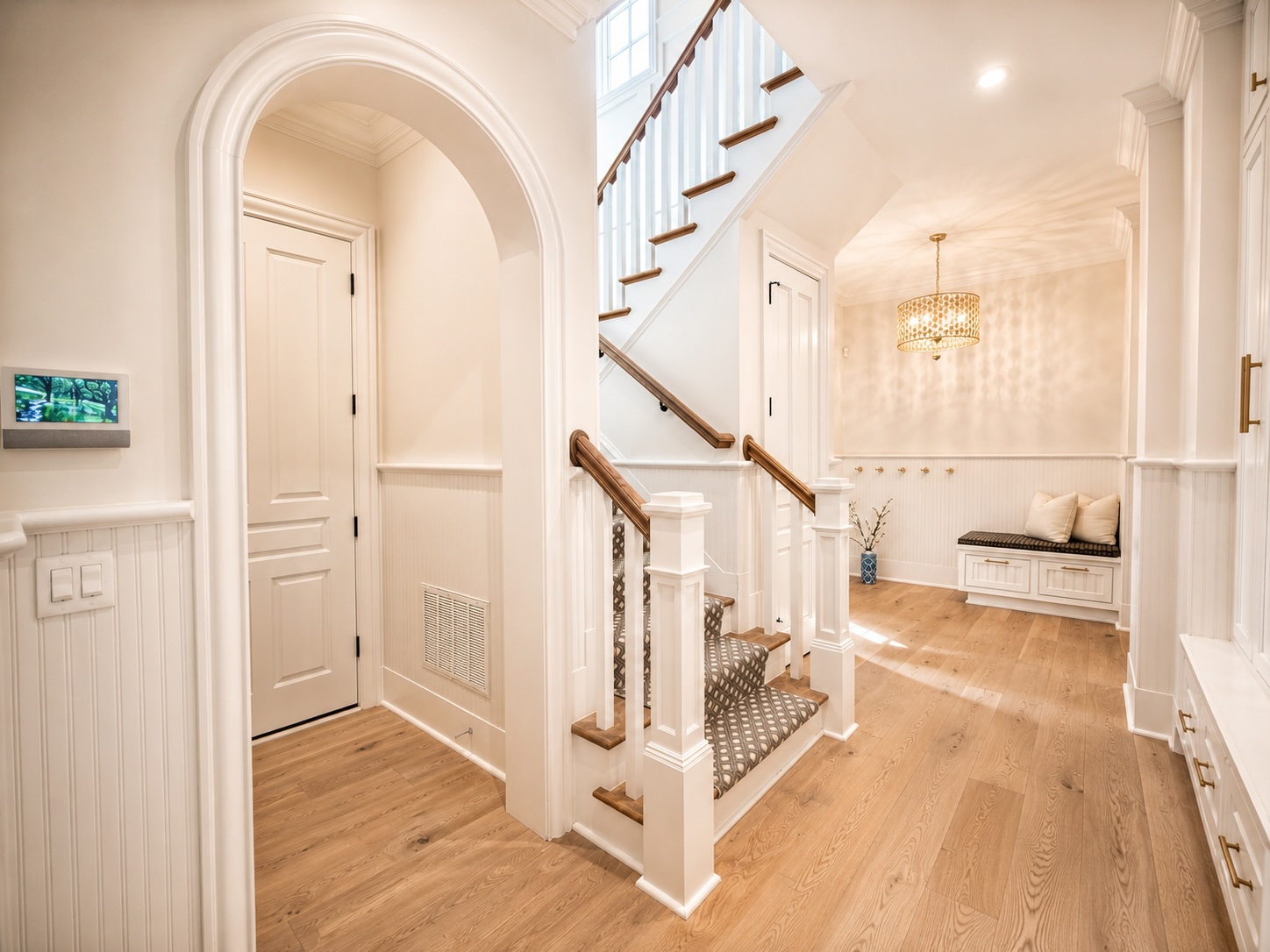 Rear hall with arched entry, mudroom bench, and back staircase