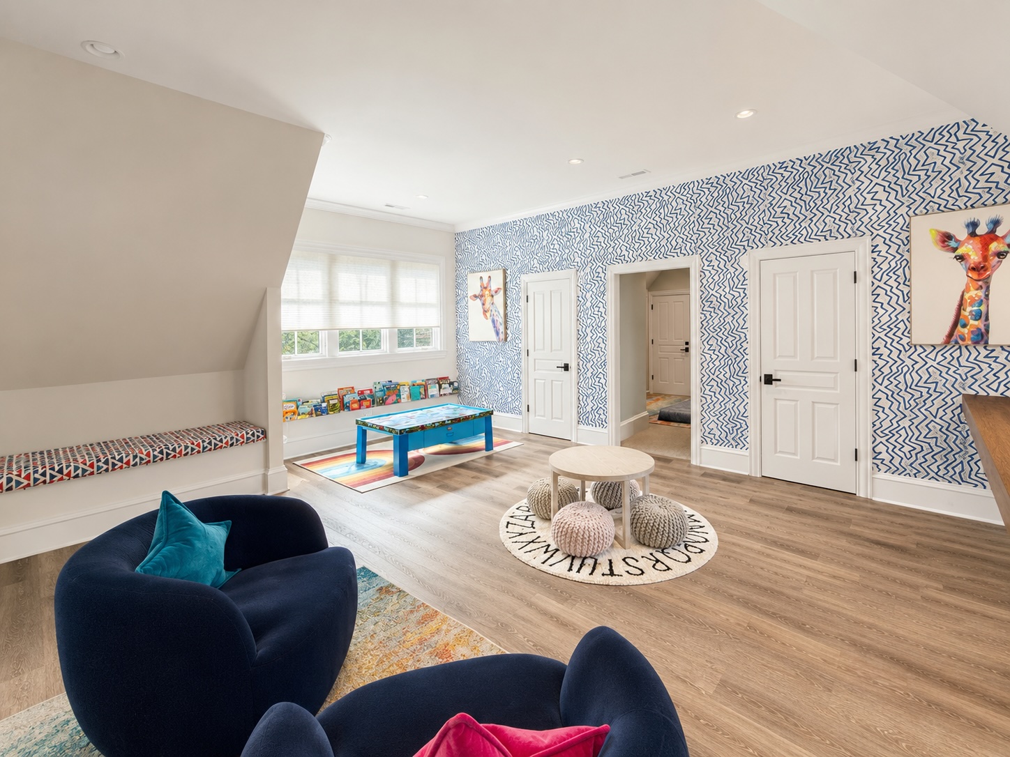 Children's playroom with patterned wallpaper, window seat, and built-in storage