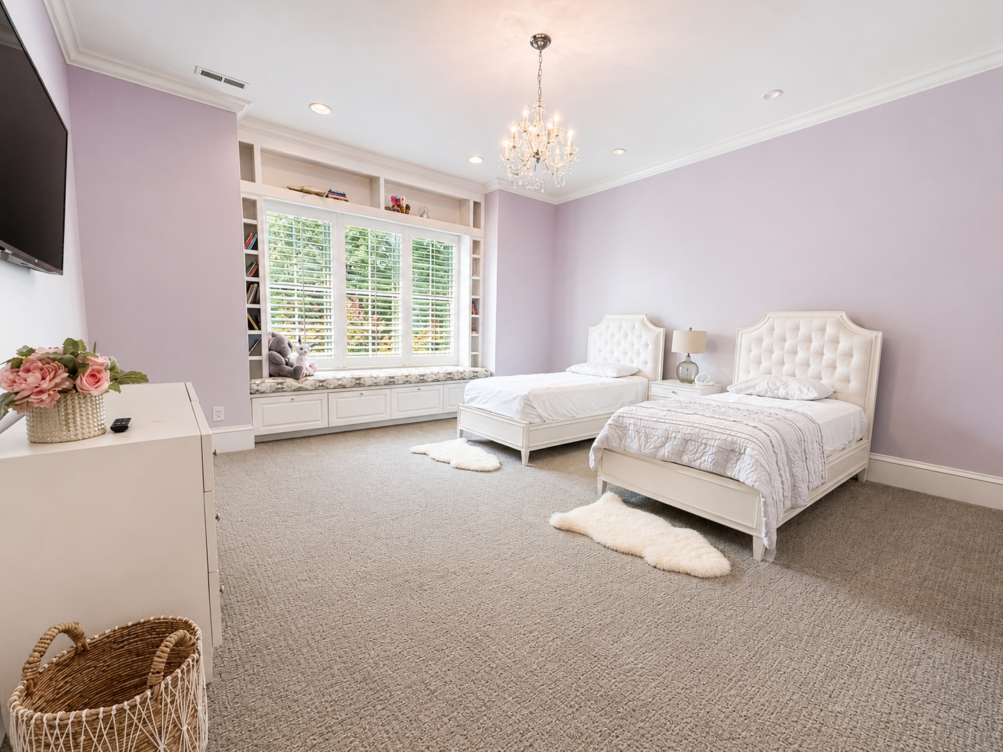 Children's bedroom with twin beds, chandelier, and window seat